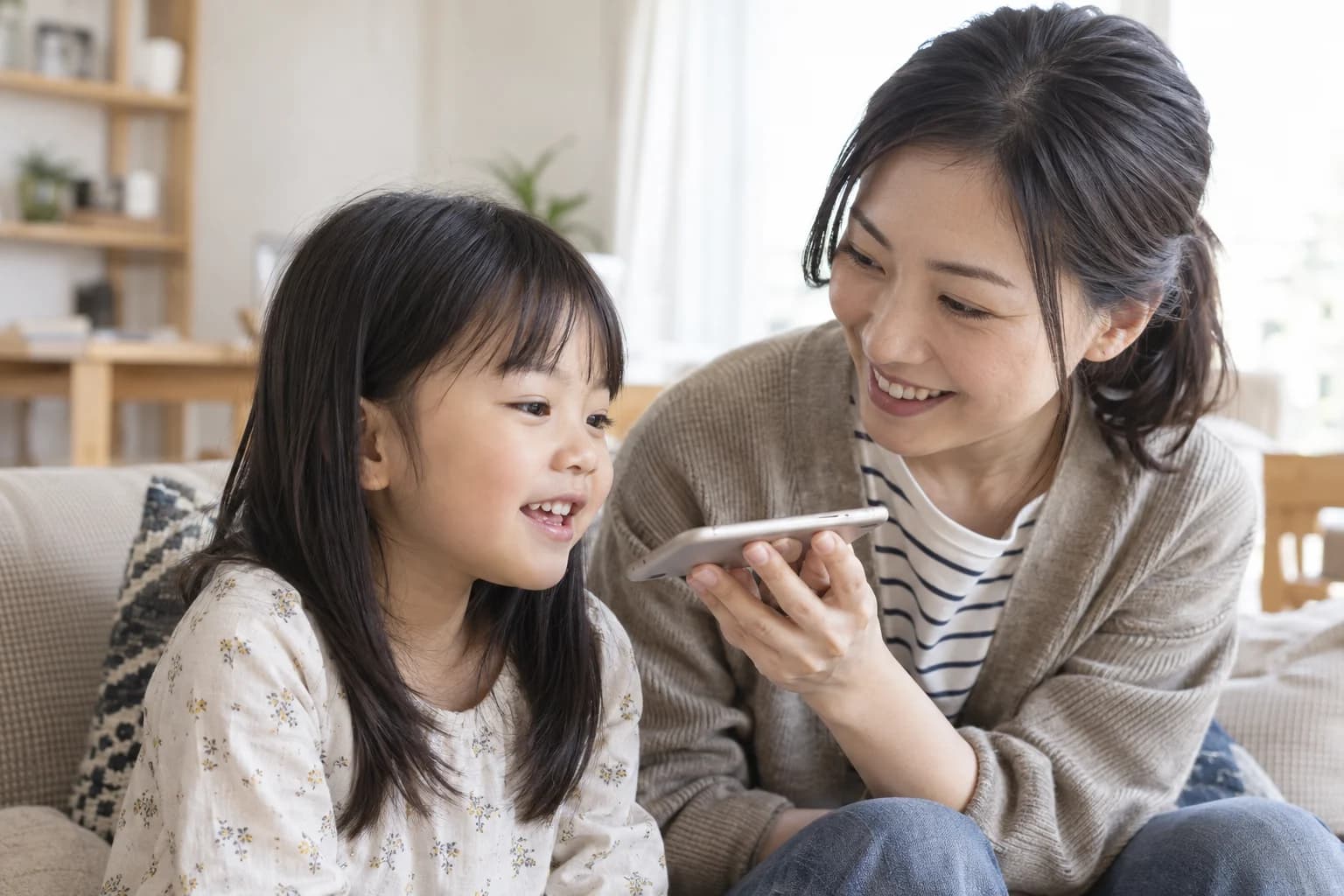 保護者にスマホを持ってもらいメッセージを録音する子どものイメージ